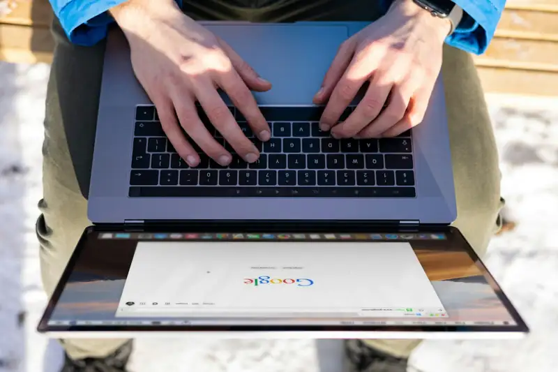 Person typing on a laptop showing a search results page